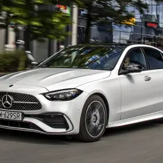 Biały Mercedes Klasy C jedzie ulicą. Ile cm ma klasa c? To zależy od wersji, ale ten model jest idealny do miasta.