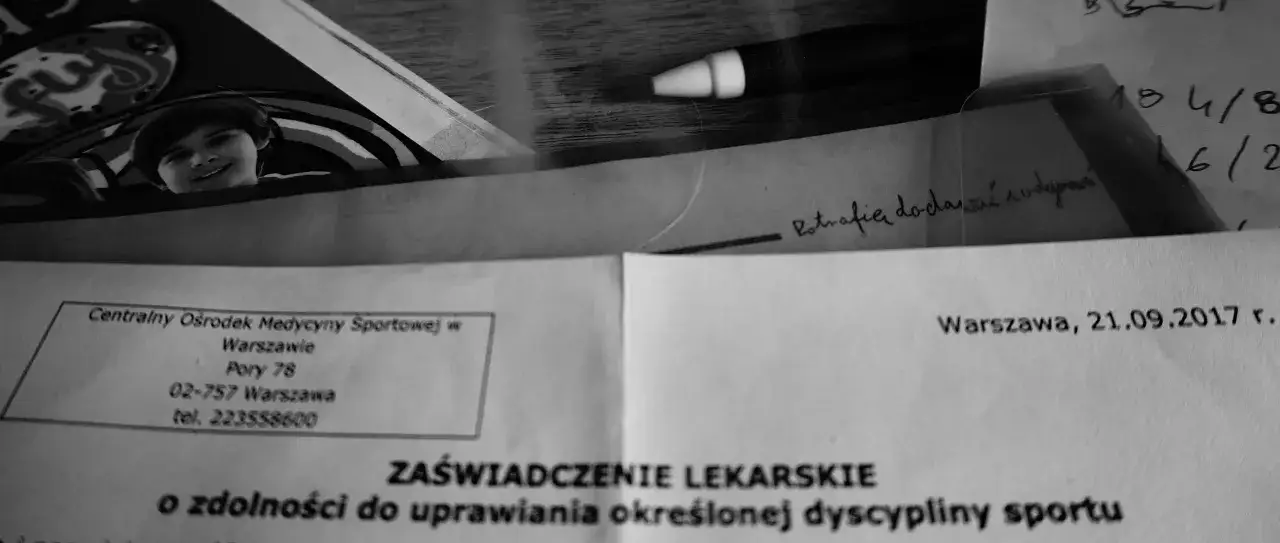 Uśmiechnięte dziecko na zdjęciu obok dokumentu z nagłówkiem 