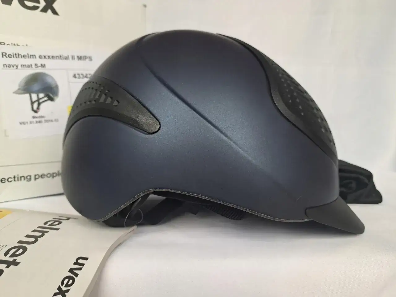 Granatowy kask jeździecki uvex z matowym wykończeniem, model Reithelm exxential II MIPS.