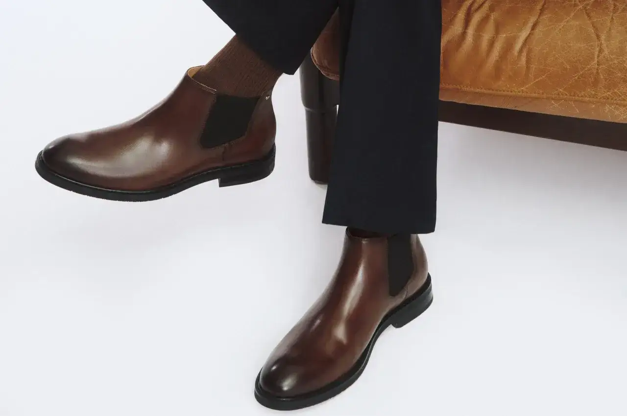 Eleganckie, brązowe sztyblety z czarnymi wstawkami. Idealne, by pokazać, jak dobrać sztyblety do stylizacji.